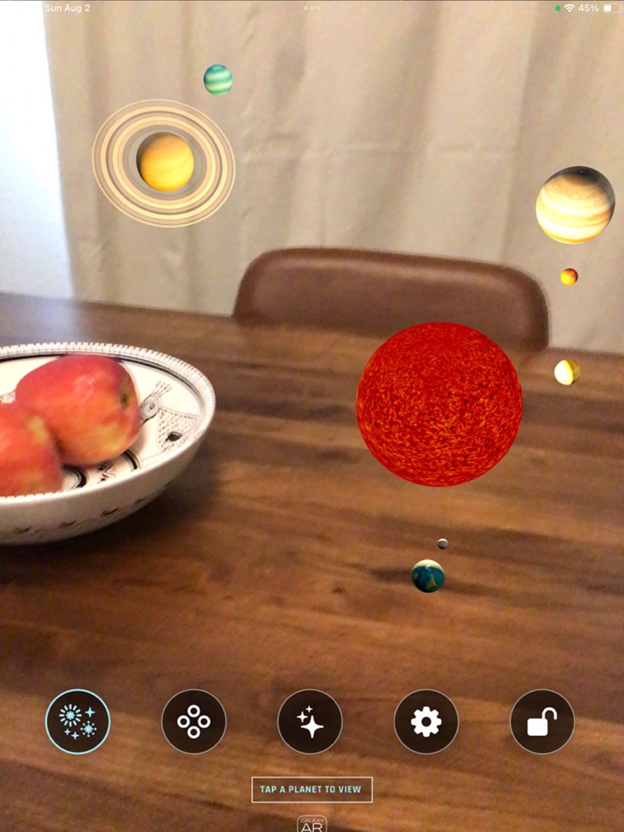 Galaxy AR room-scale solar system on iPad with the Sun and planets displayed across a room